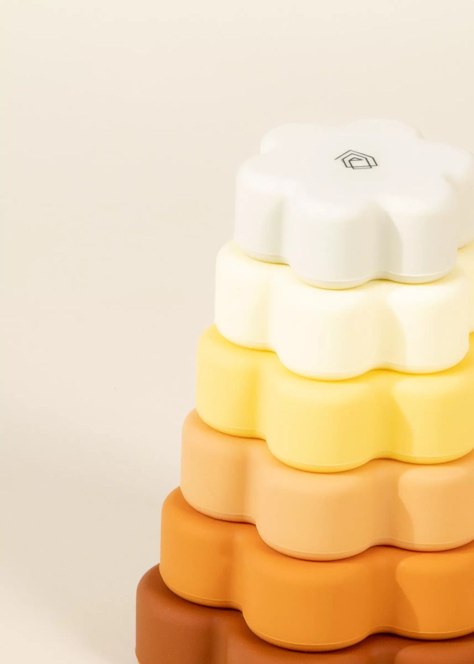 Stack of colorful silicone baby blocks on a beige background