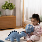 Child playing with blue dinosaur toys on a light-colored rug.