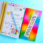 Notebook with colorful stickers and pen on a bright background