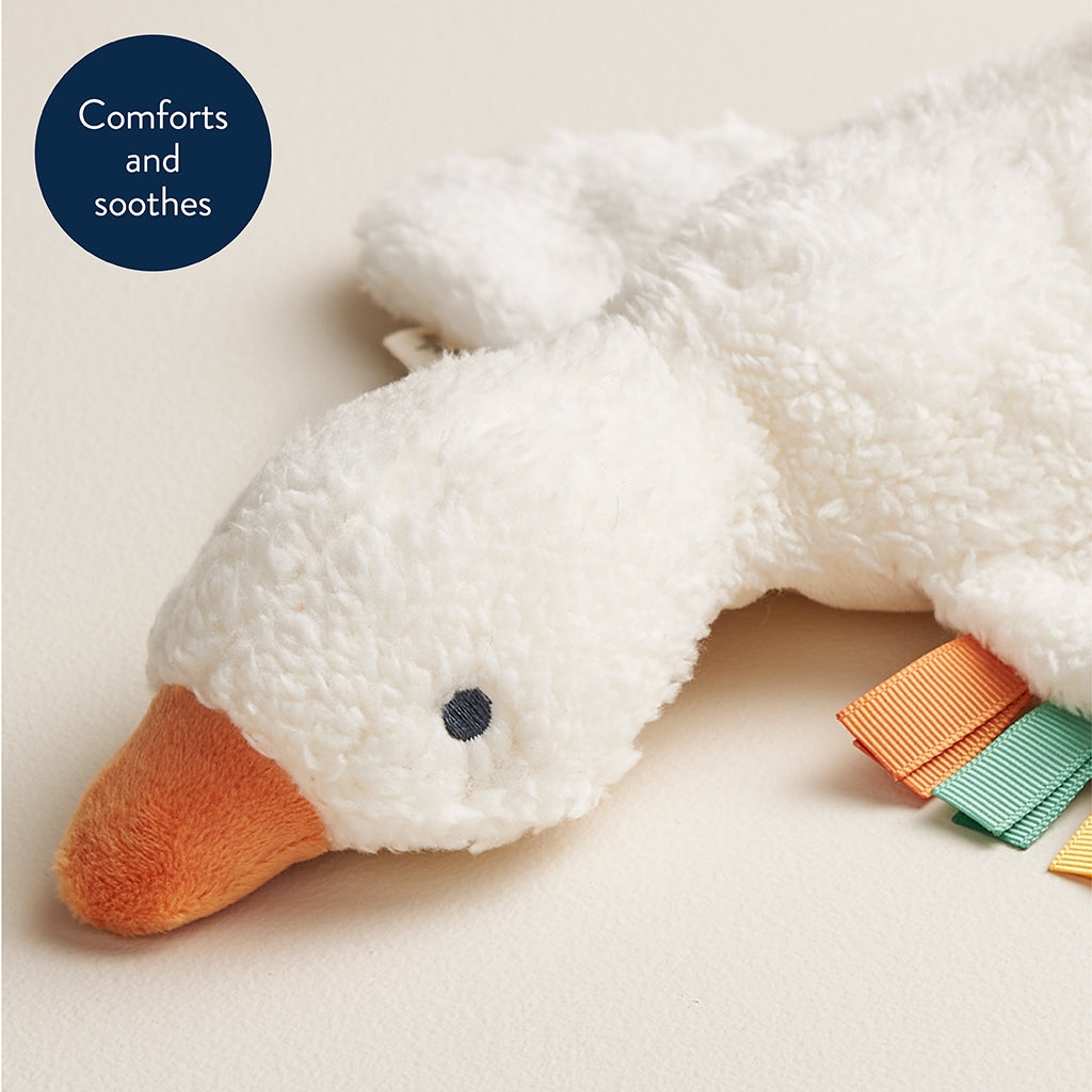 White plush toy duck with colorful tags on a light background