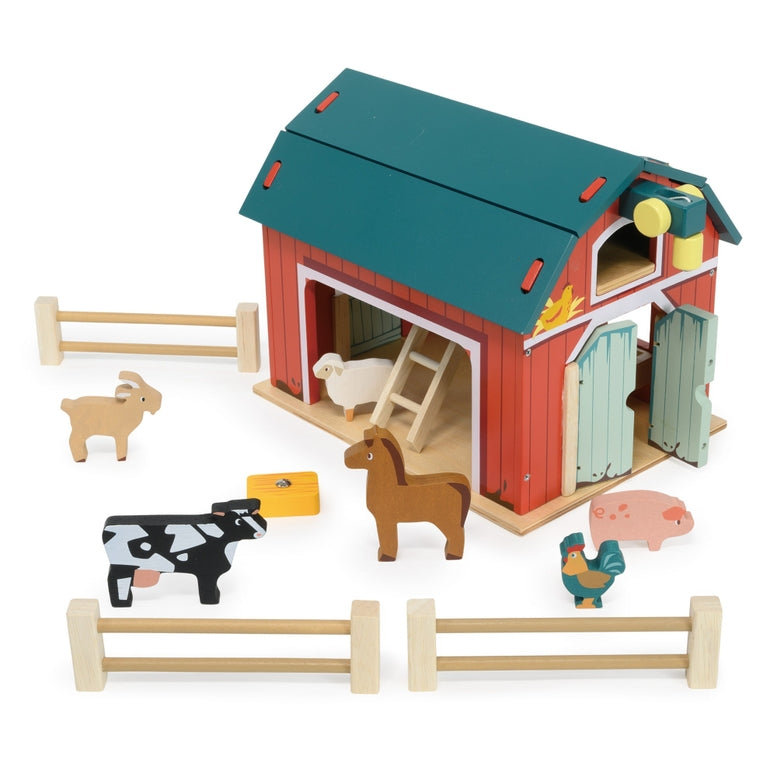 Wooden Big Red Barn Playset by Mentari set against a clean white background, showcasing the complete set including the two-story red and green barn, opening double doors, a working pulley system with a yellow magnetic hay bale, wooden fence sections, a blue ladder, and small wooden animal figures including a cow, horse, pig, sheep, goat, chicken, and rooster.