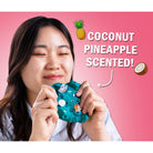 Person holding a coconut pineapple scented product with text on a pink background