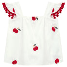 White dress with red apple designs and ruffled sleeves on a white background
