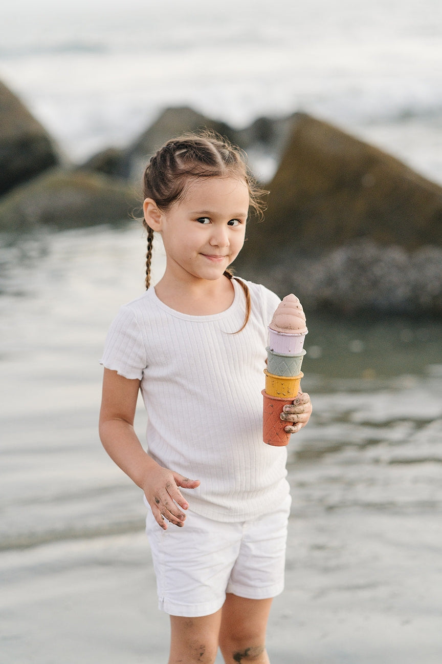 Young girl playing with sand toys on a beach