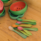 Colorful children's bowl and spoon set on a wooden surface