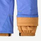 Close-up of a pair of blue and tan insulated pants showing the cuff details, including reflective striping and elasticated openings.