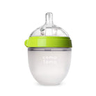 Baby bottle with green cap and white body on a white background