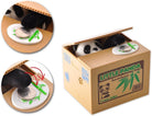 Toy panda inside a cardboard box labeled 'Little Panda Bamboo' with bamboo sticks and leaves.