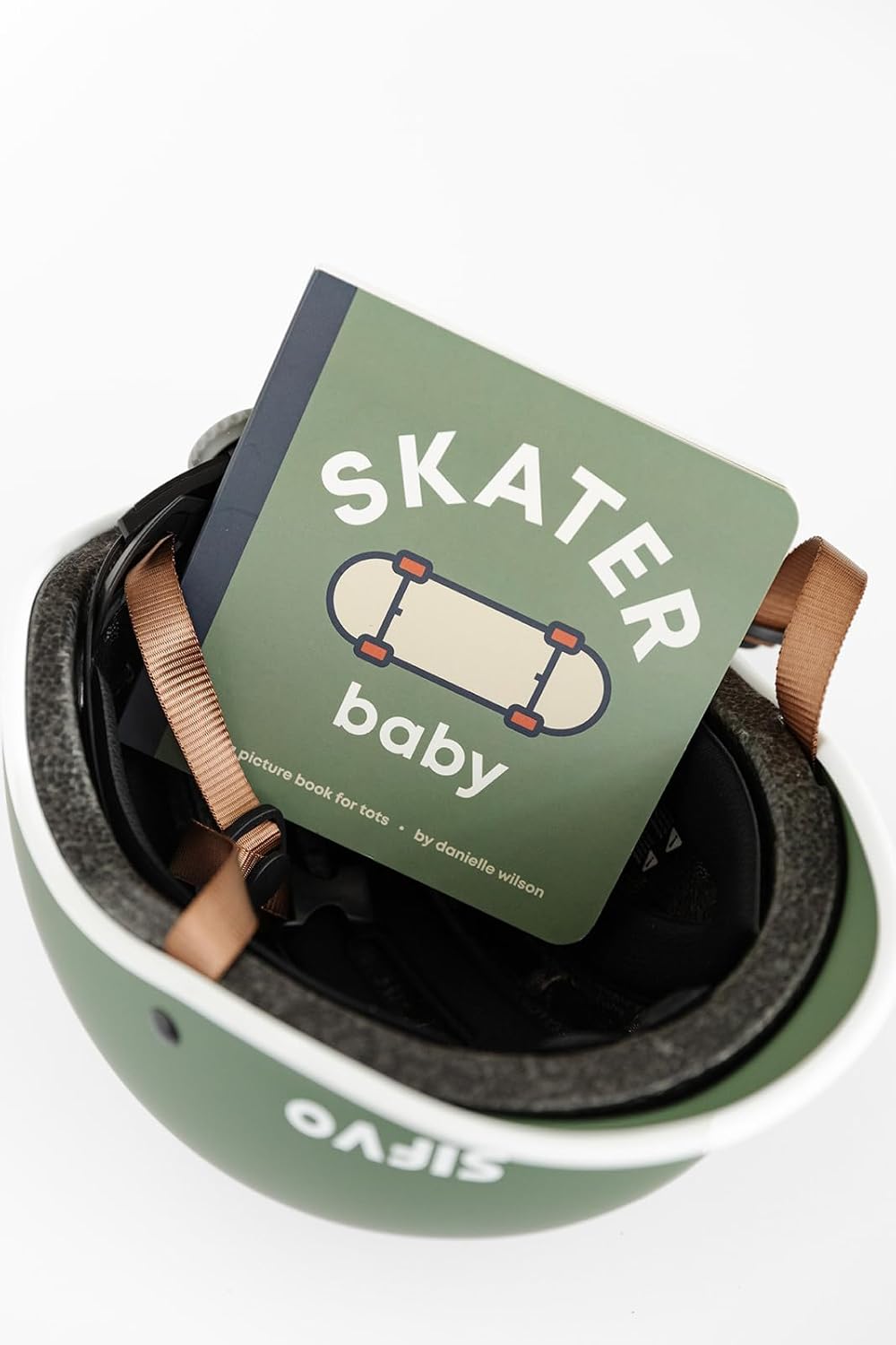 Green helmet with a book titled 'Skater Baby' on a white background