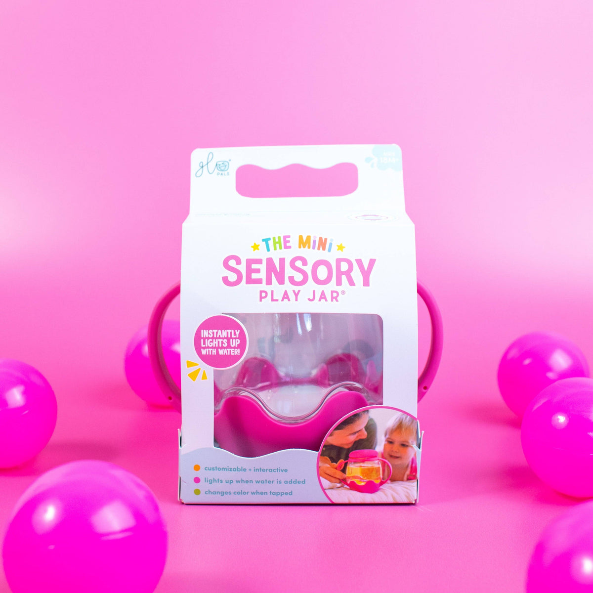 Sensory play jar packaging with pink balls on a pink background