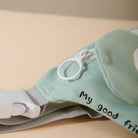 Light blue baby outfit with text on a beige background