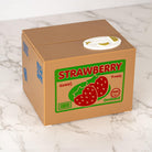 Cardboard box with strawberry label on a marble surface