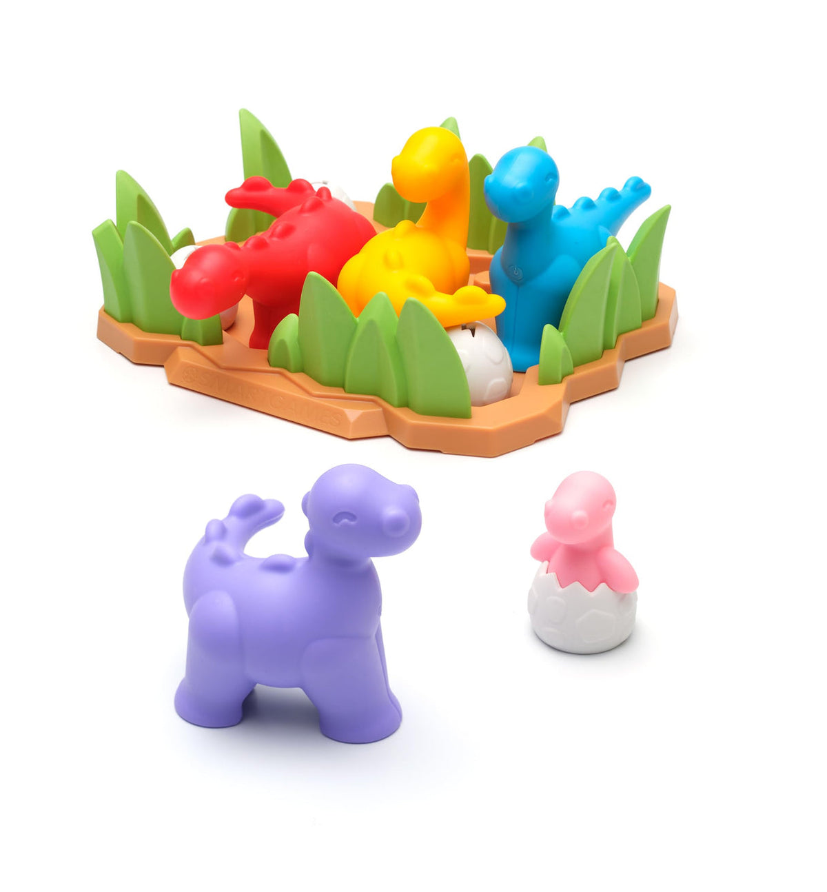 A colorful children's toy set featuring a base with green grass and dinosaur figures in red, yellow, and blue, plus two loose dinosaur figures in purple and pink-and-white egg shapes, photographed on a white background.