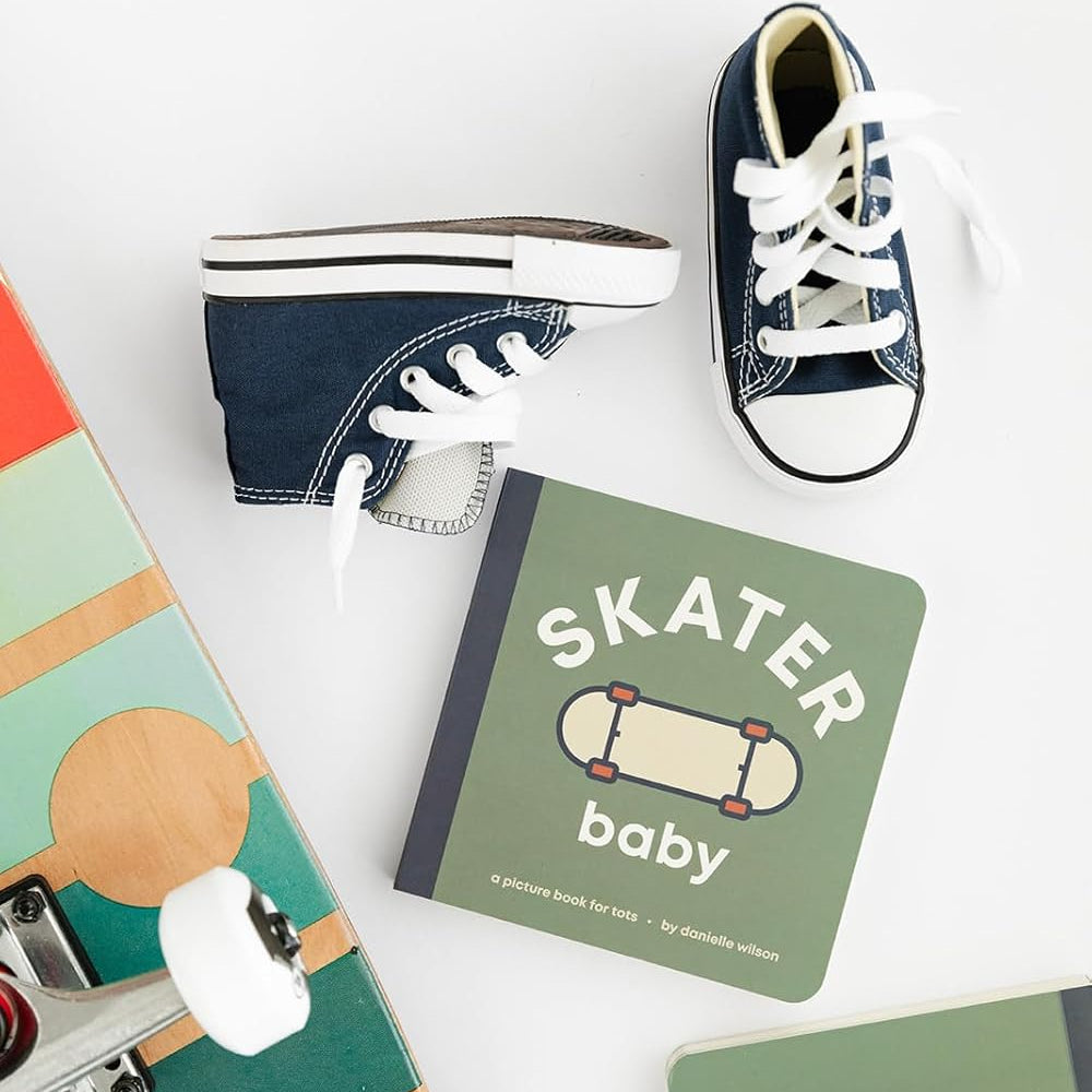 Children's book titled 'Skater Baby' with a pair of navy blue sneakers on a white background