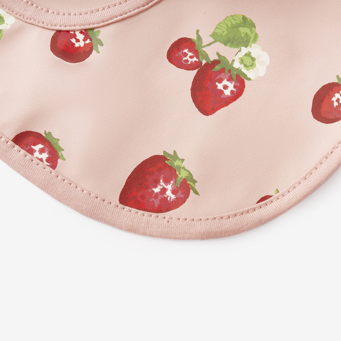 Pink bib with strawberry pattern on a white background