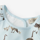 Close-up of a baby outfit with duck pattern and visible brand label on light blue fabric.