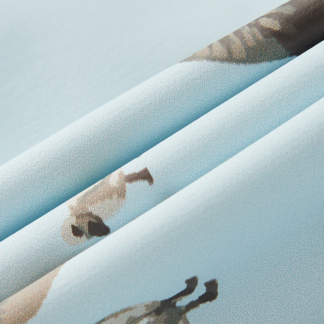 Close-up of textured fabric with abstract patterns on a light blue background