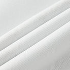 Close-up of white fabric with a textured pattern on a light gray background