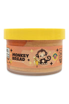 A jar of Monkey Bread Peanut Butter Cookies by Monkey Wrench Cookies, featuring a bright yellow lid and a peach-colored label with a cartoon monkey holding a banana.