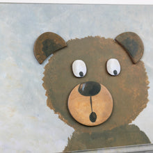Cartoon bear face with googly eyes on a textured background