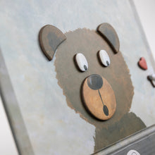 Close-up of a bear-shaped phone case with a textured surface