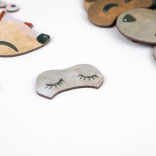 Metallic dog tags with engraved designs on a white background