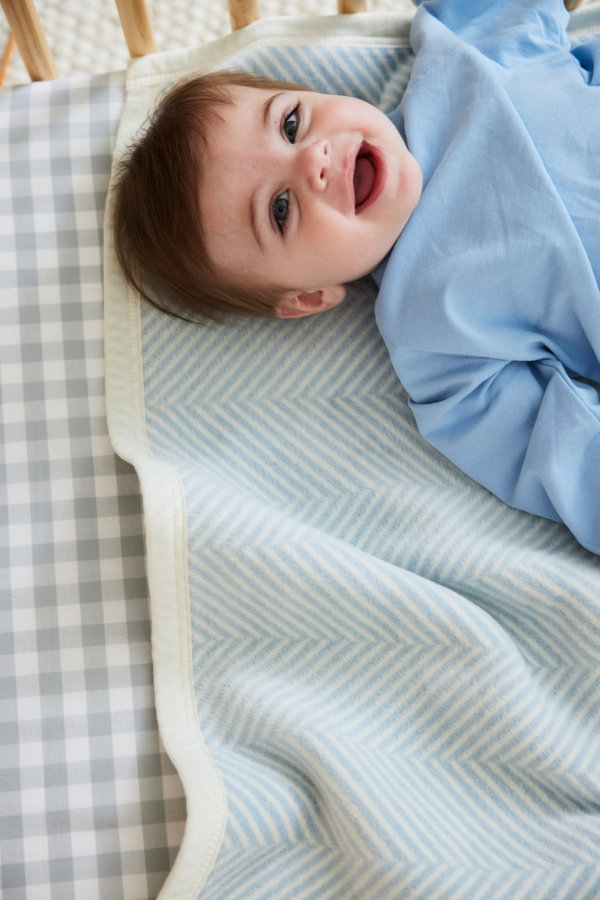 Baby's a light blue blanket with a striped background