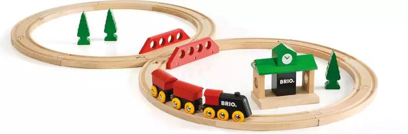 Wooden train set with tracks, train, and a building on a white background