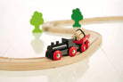 Toy train on a wooden track with green trees on a white background