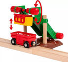 Toy train track set with a red wagon and green and yellow mechanical component on a white background