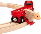 Wooden toy train set with red wagon and animal figure on a white background