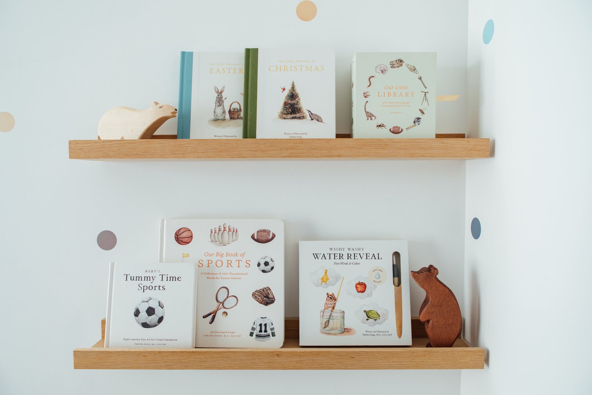 Wooden shelves with children's books and toys against a light blue wall.