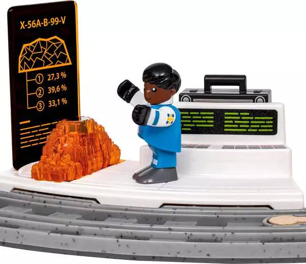 A toy construction vehicle scene with a blue and white minifigure standing beside a black control panel, an orange translucent rock, and a black display screen showing statistics, all on a white and gray vehicle base against a white background.