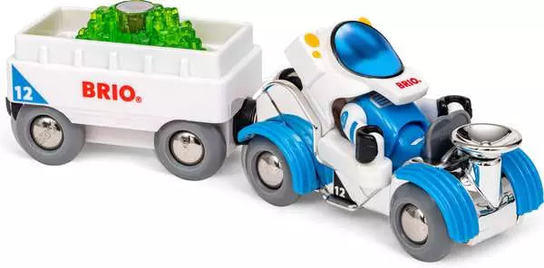 A Space Deluxe Set by Brio white and blue space rover vehicle with an attached white cargo wagon carrying a load of glowing green crystals.