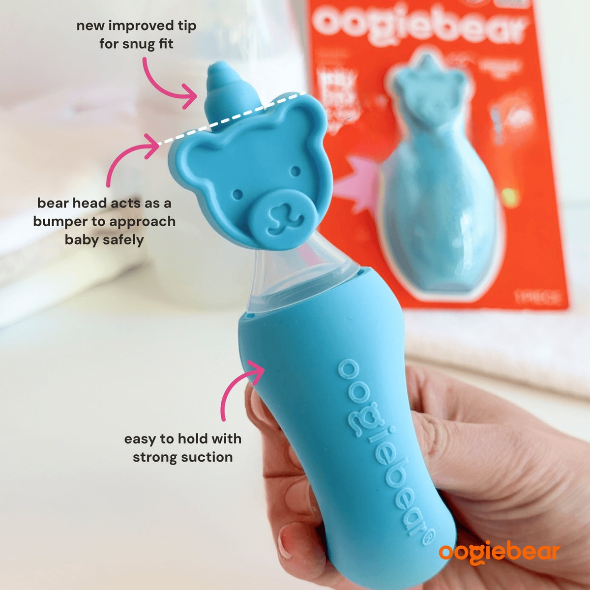 Blue oogiebear product held by a hand with text highlighting features, against a white background.
