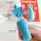 Blue oogiebear product held by a hand with text highlighting features, against a white background.
