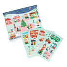 A product photo of the Christmas Town Mini Sticker Set by Petit Collage featuring multiple green sticker sheets fanned out with festive illustrations of holiday buildings, vehicles, and characters.