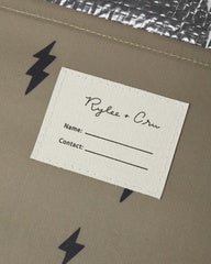 A close-up of a kraft paper envelope or gift bag with black lightning-bolt graphics, featuring a white paper insert card with printed text fields.