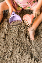 Children playing in sand with toys on a beach