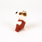 Stuffed toy dog with a red romper on a white background - from the side