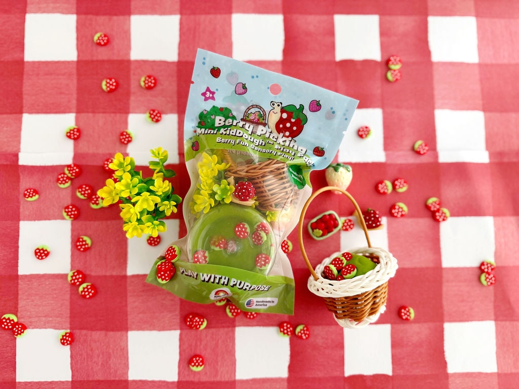 Product packaging with a basket and flowers on a red and white checkered tablecloth.