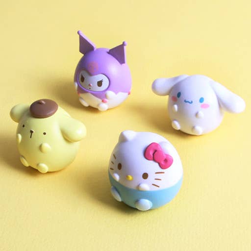 Four colorful cartoon character figurines on a yellow background