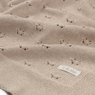 Textured beige blanket with a 'il & me' label