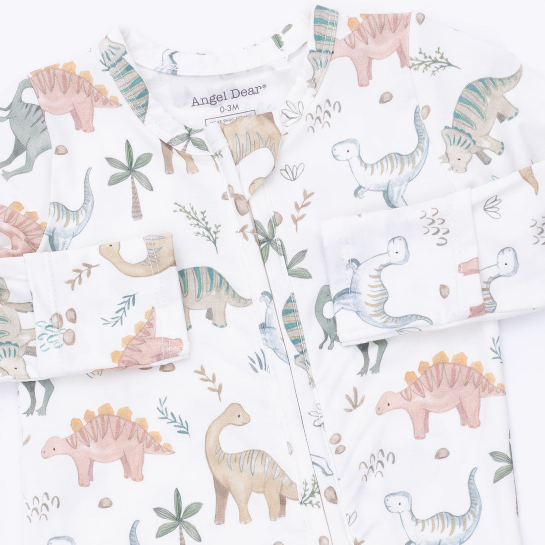 A children's long-sleeve pajama top by Angel Dear, featuring a white base with a colorful dinosaur and plant print. The pajama has a button-down front, button closures, and a crew neck with the brand name 'Angel Dear' visible inside the collar.