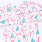 A white long-sleeve baby pajama top with a festive Christmas print featuring pink bows, teal and pink Christmas trees, and small gold stars.