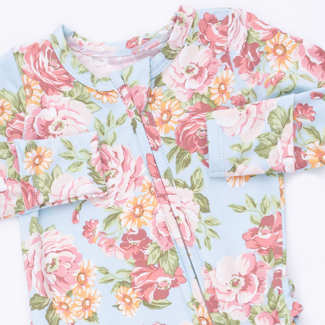 Floral patterned fabric with pink and green flowers on a light blue background