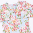 Floral patterned fabric with pink and green flowers on a light blue background