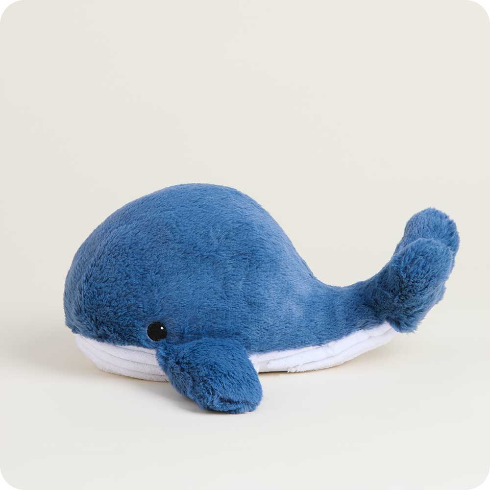 Blue plush whale toy on a light beige background