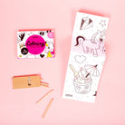 Coloring book, pencil, and eraser on a pink background