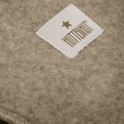 Close-up of a label with 'HUTTE & CO' text on a textured brown fabric background